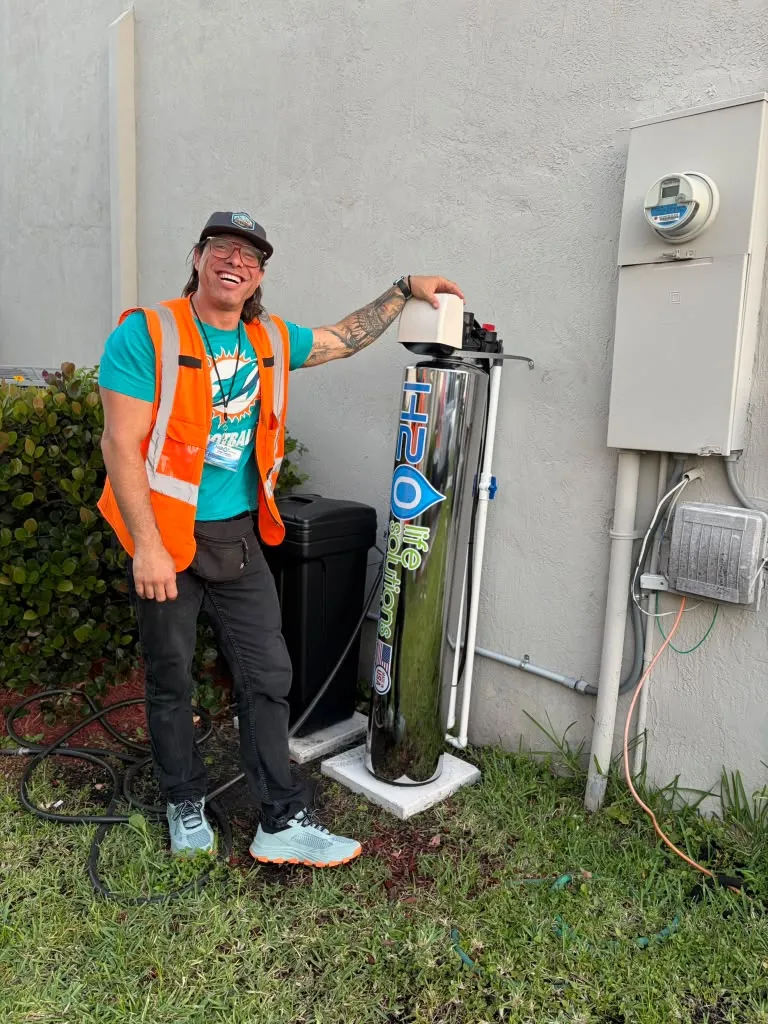 Jorge Canela next to a whole-home water system he installed